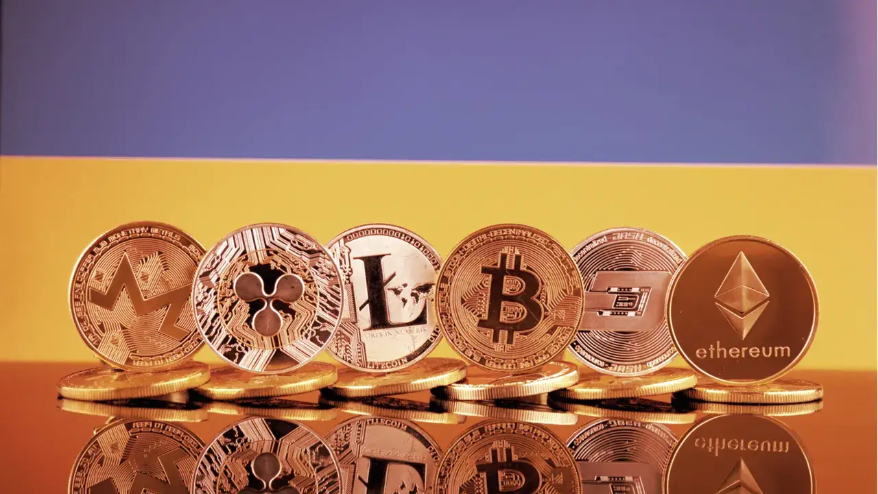Монети біткоїна, Ethereum та інших криптовалют на тлі кольорів прапора України